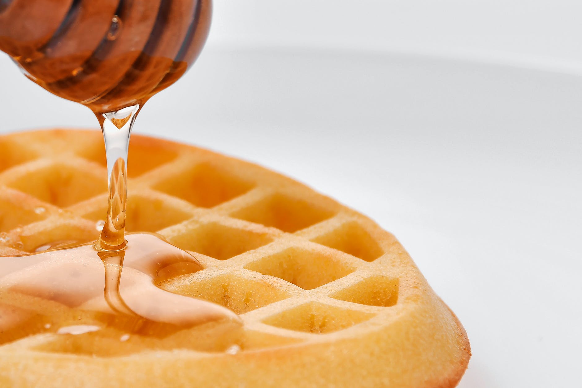close up shot of a waffle with honey